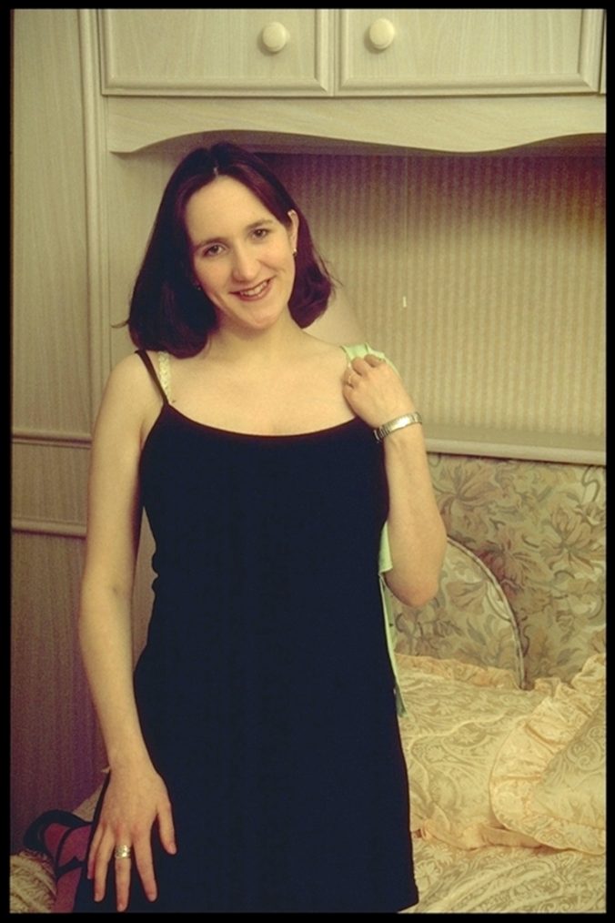 Lächelnde Frau im schwarzen Kleid